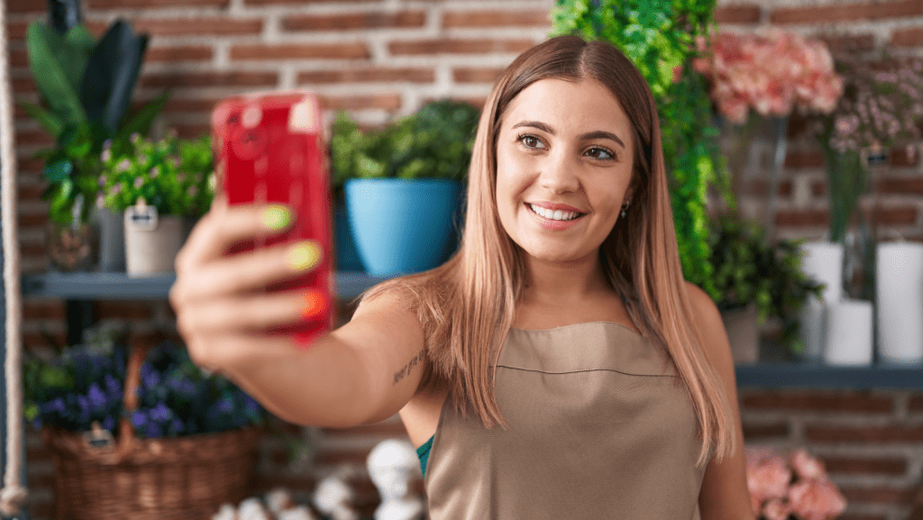 Dueña de la florería filmando un vídeo con su móvil