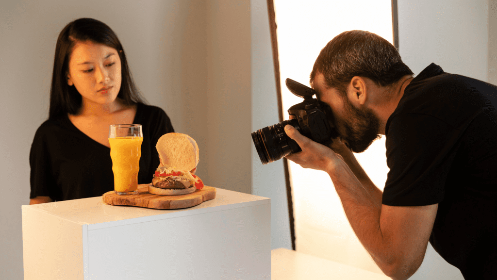 Hombre tomando fotografía a una hamburguesa 