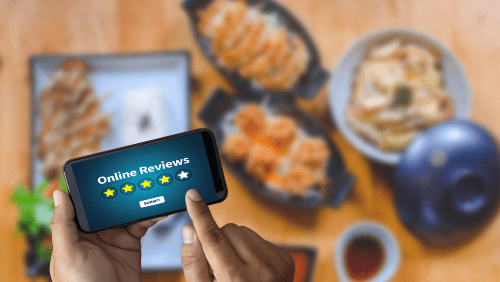Persona dejando una reseña con su móvil en un local de comidas