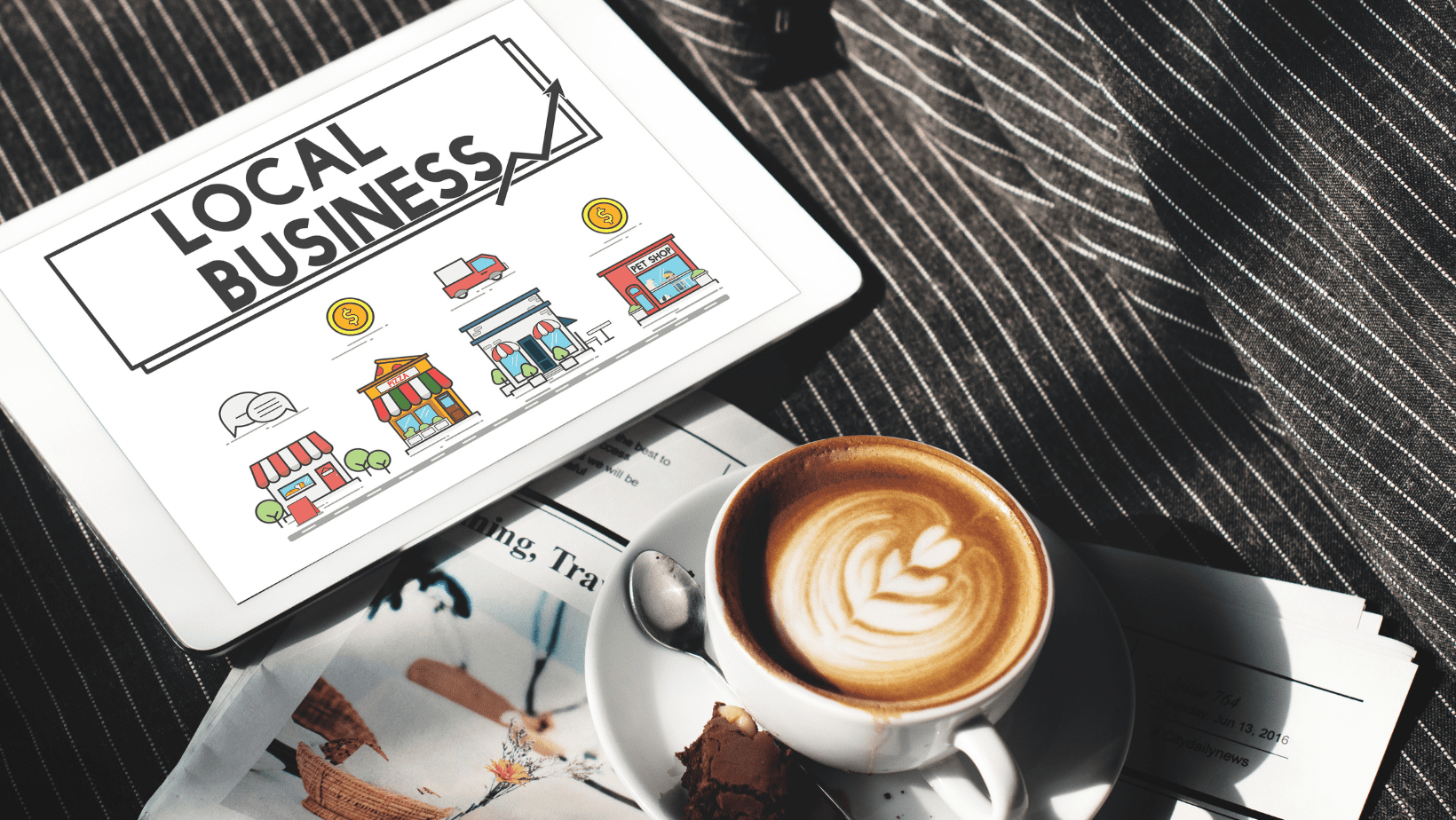 Una taza de café y una Tablet donde se ve el business profile de un negocio