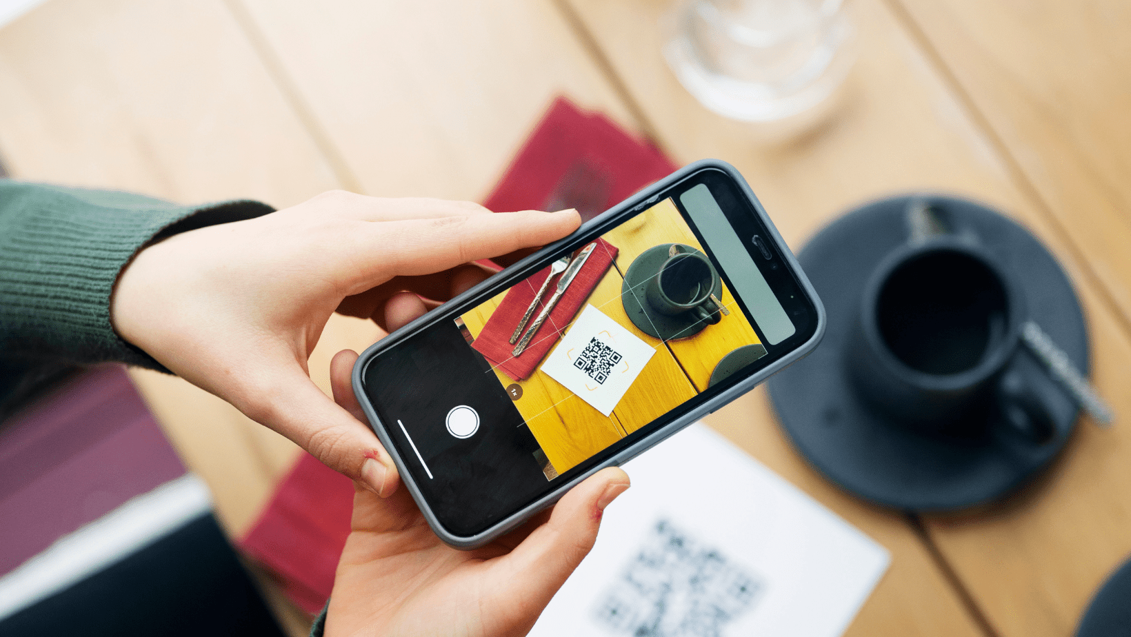 Persona escaneando código QR para dejar una reseña en una cafetería