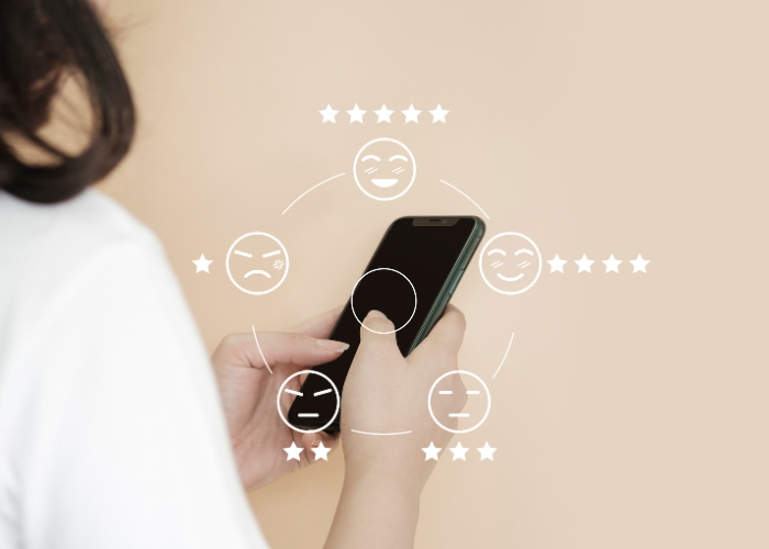 Personne utilisant un smartphone avec une interface visuelle de notes et d'émojis de satisfaction autour, représentant la gestion automatisée des avis avec wiReply et l'optimisation de la réputation en ligne par l'intelligence artificielle.
